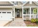 Close-up of the front porch featuring a welcome sign, hanging swing, and brick pathway at 1502 Checker Ct, Mount Pleasant, SC 29466