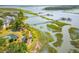 Beautiful aerial view of waterfront homes with manicured landscaping, a pond, and a dock, set against a marsh backdrop at 1607 Folly Creek Way Way # C-5, Charleston, SC 29412