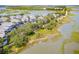 Picturesque aerial view of waterfront homes surrounded by lush trees and marshlands, creating a tranquil coastal setting at 1607 Folly Creek Way Way # C-5, Charleston, SC 29412