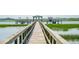 Scenic wooden walkway leading to a private boat dock, offering easy access to the water and coastal adventures at 1607 Folly Creek Way Way # C-5, Charleston, SC 29412