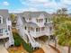 Three story elevated beach home with wrap-around porch, lush greenery, and mature trees at 1607 Folly Creek Way Way # C-5, Charleston, SC 29412