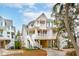 Three story elevated beach home with wrap-around porch and white railings at 1607 Folly Creek Way Way # C-5, Charleston, SC 29412