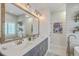 Elegant bathroom featuring dual sinks, a large mirror, and stylish fixtures with plenty of natural light at 1702 Sparkleberry Ln, Johns Island, SC 29455