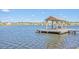 View of a lakefront dock with covered seating area overlooking the serene water at 1702 Sparkleberry Ln, Johns Island, SC 29455
