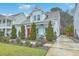 Charming two-story home featuring a landscaped front yard, bright red door, and light blue window shutters at 1702 Sparkleberry Ln, Johns Island, SC 29455