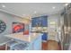 Well-lit kitchen featuring stainless steel appliances, blue cabinets, a central island with seating and hardwood floors at 1702 Sparkleberry Ln, Johns Island, SC 29455