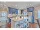 Charming kitchen with blue cabinets, white countertops, stainless steel appliances and a central island with seating at 1702 Sparkleberry Ln, Johns Island, SC 29455