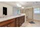 Bathroom featuring dual sinks with marble countertop and a shower with glass door and beige tile surround at 1886 Omni Blvd, Mount Pleasant, SC 29466
