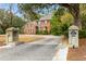 Charming brick home featuring symmetrical design, black shutters, mature trees, and private driveway at 1886 Omni Blvd, Mount Pleasant, SC 29466