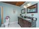 Bathroom featuring a dual sink vanity with granite countertop and decorative mirrors, plus a toilet with flower arrangement at 2015 Albert Storm Ave, Moncks Corner, SC 29461