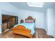Bedroom featuring rustic wood floors, a decorative wooden bed frame, and a view into an adjacent room with wood paneling at 2015 Albert Storm Ave, Moncks Corner, SC 29461