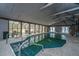 Indoor pool in a spacious room with high ceilings, large windows, lounge chairs, and access ladders for safety and convenience at 2015 Albert Storm Ave, Moncks Corner, SC 29461