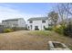 A large back yard with a patio, outdoor furniture, wooden fence, and other homes in the background at 2025 Lanneau Ln, Johns Island, SC 29455