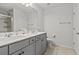 A bright bathroom featuring a double vanity with a shared mirror, cabinets, and tile flooring at 2025 Lanneau Ln, Johns Island, SC 29455