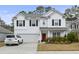 Charming two-story home boasts a bright red front door and a two-car garage at 2025 Lanneau Ln, Johns Island, SC 29455
