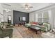 Cozy living room featuring a plush green sofa, colorful rug, ceiling fan, and dark accent wall at 2025 Lanneau Ln, Johns Island, SC 29455