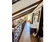 Long hallway with exposed beams and hardwood floors lit by natural light at 204 Chamblee Rd, Walterboro, SC 29488