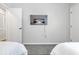 Neutral bedroom featuring a wall-mounted TV between two white doors above two twin beds at 208 Kentucky Dr, Ladson, SC 29456
