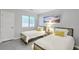 Bright bedroom featuring two twin beds with white bedding and a nightstand under a window with blinds at 208 Kentucky Dr, Ladson, SC 29456