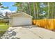 This is a garage and driveway featuring a basketball hoop with a wooden fence behind at 208 Kentucky Dr, Ladson, SC 29456