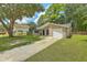 Charming single-story home featuring a well-maintained lawn, an attached garage and mature trees at 208 Kentucky Dr, Ladson, SC 29456