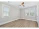 Bedroom with hardwood floors, two shuttered windows, ceiling fan, and grey walls at 2123 Boatwright Rd, Johns Island, SC 29455