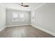 This bedroom has wood-look floors, a ceiling fan, base moulding, and two windows with blinds at 2123 Boatwright Rd, Johns Island, SC 29455