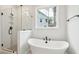 Luxurious bathroom with soaking tub, glass-enclosed shower, black matte hardware and window views at 2181 Blue Bayou Blvd, Johns Island, SC 29455