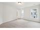 A spacious bedroom with neutral carpet, two windows, and a door at 2181 Blue Bayou Blvd, Johns Island, SC 29455