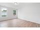 An empty bedroom features two windows, hardwood floors, and neutral-colored walls at 2181 Blue Bayou Blvd, Johns Island, SC 29455