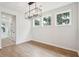 A dining area is illuminated by a chandelier and three large windows at 2181 Blue Bayou Blvd, Johns Island, SC 29455