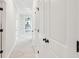 A hallway leads to a glass door and features white walls and multiple closets at 2181 Blue Bayou Blvd, Johns Island, SC 29455