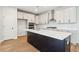 A modern kitchen features stainless steel appliances, an island, and bright lighting at 2181 Blue Bayou Blvd, Johns Island, SC 29455