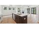 A kitchen island with a sink faces a fireplace and French doors leading to the yard at 2181 Blue Bayou Blvd, Johns Island, SC 29455