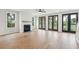 Spacious living area featuring hardwood floors, a modern fireplace, and dark trim doors to covered patio at 2181 Blue Bayou Blvd, Johns Island, SC 29455