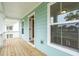 Side porch with light blue siding features a wood floor and access to the home at 2181 Blue Bayou Blvd, Johns Island, SC 29455