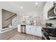 Open-concept kitchen with stainless appliances, granite counters, white cabinets and easy access to the staircase at 221 Abercom Place Dr, Moncks Corner, SC 29461