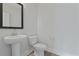 A minimalist powder room featuring a pedestal sink, toilet, and modern fixtures against a light color scheme at 2225 Blue Bayou Blvd, Johns Island, SC 29455