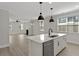 Bright kitchen with a marble island, stainless sink, and a view into the living room at 2225 Blue Bayou Blvd, Johns Island, SC 29455