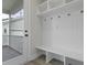 Mudroom with bench, hooks, and white trim beside an exterior glass door at 2225 Blue Bayou Blvd, Johns Island, SC 29455
