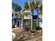 Charming two-story blue townhome featuring a pergola-covered entrance and surrounded by lush palm trees at 2905 Sweetleaf Ln, Johns Island, SC 29455