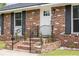 Close-up of the home's brick facade, steps, and entryway featuring black shutters at 2916 Marginal Rd, Charleston, SC 29414
