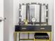 Modern vanity area with illuminated makeup mirror, black countertop, gold accents, and storage drawers at 2916 Marginal Rd, Charleston, SC 29414