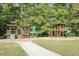 Wooden train and playground equipment surrounded by lush trees and green grass at 315 Flyway Rd, Goose Creek, SC 29445
