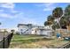 Spacious backyard with a picnic table and fire pit surrounded by tropical palm trees at 407 Palmetto Blvd, Edisto Beach, SC 29438