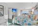Bright bedroom featuring a coastal aesthetic, with a television and balcony overlooking the ocean at 407 Palmetto Blvd, Edisto Beach, SC 29438