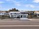 Street view of a light grey beach house with double porches at 407 Palmetto Blvd, Edisto Beach, SC 29438