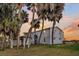 View of the side of the beach house through the palm trees at 407 Palmetto Blvd, Edisto Beach, SC 29438