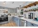 Well-lit kitchen with stainless steel appliances, stylish backsplash, and convenient open shelving in neutral colors at 407 Palmetto Blvd, Edisto Beach, SC 29438