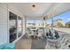 Serene screened porch featuring wicker seating and table, offering a relaxing outdoor experience with neighborhood views at 407 Palmetto Blvd, Edisto Beach, SC 29438